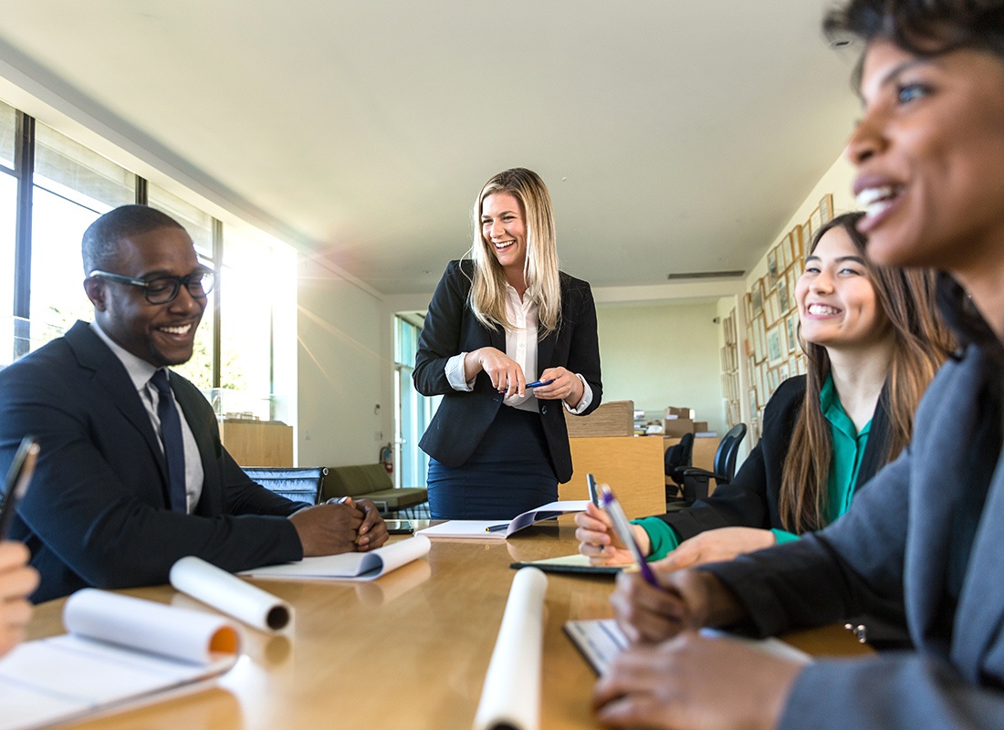 Insurance Solutions - Friendly Business Colleagues Sit Together and Laugh During an Office Meeting