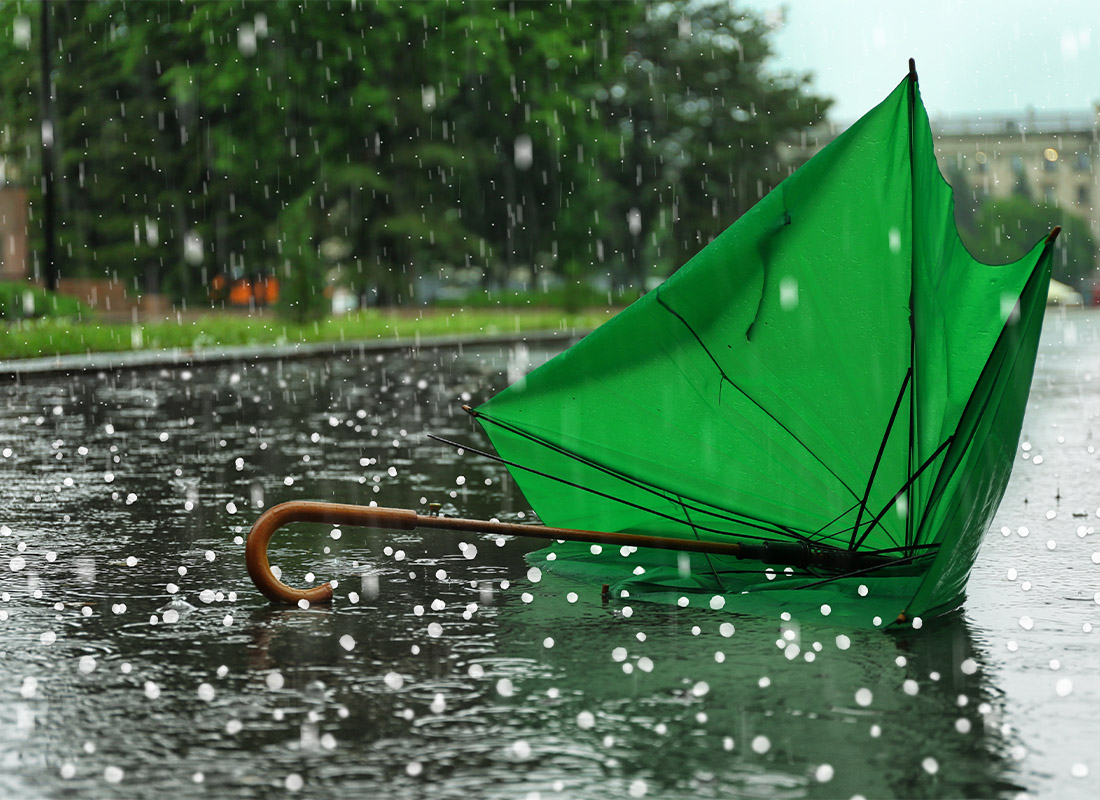 Wind and Hail Coverage - Broken Green Umbrella With Hail Falling From the Sky